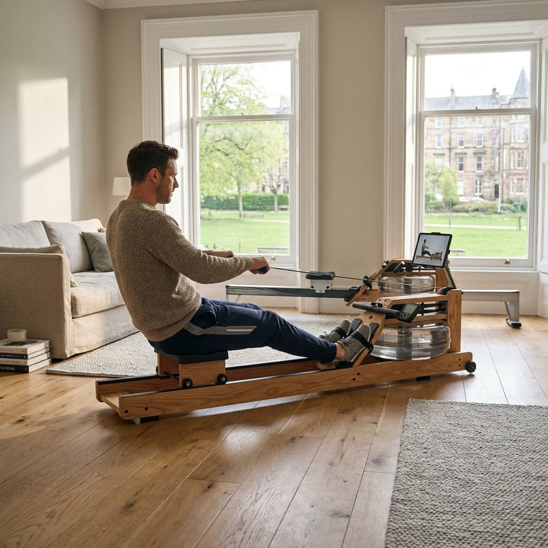 Persoon traint op een compacte roeitrainer in een moderne, lichte woonkamer met houten vloer, rustige styling en een premium thuisfitness uitstraling.